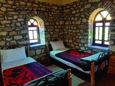 a room with two beds and two windows at Auberge Restaurant Telouet in Telouet
