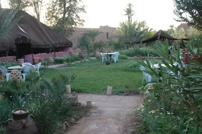 a garden with chairs and a table and a tent at d'hôte Jnane-Dar Diafa in Tamegroute