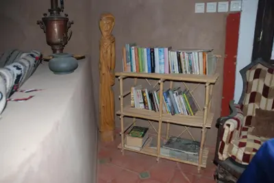 a book shelf filled with books in a room at d'hôte Jnane-Dar Diafa in Tamegroute