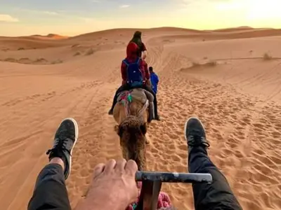 a person riding an elephant in the desert at Luna del fuego in Ifri