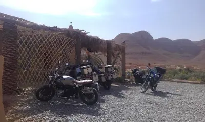 two motorcycles parked next to a fence in the desert at Luna del fuego in Ifri