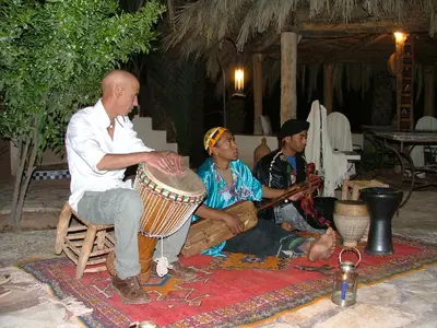 a group of people sitting around playing instruments at Maison d'Hôtes Kasbah Azul in Agdz