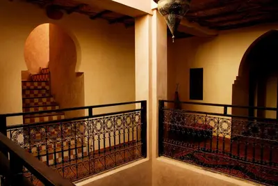 a balcony with a wrought iron railing and stairs at Maison d'Hôtes Kasbah Azul in Agdz