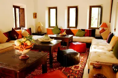 a living room with couches and a table with a vase at Maison d'Hôtes Kasbah Azul in Agdz