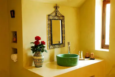 a bathroom with a green sink and a mirror at Maison d'Hôtes Kasbah Azul in Agdz