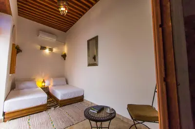 a room with two beds and a table at Dar Bhija in Fès