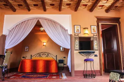 a bedroom with a bed with a red blanket at Dar Amoudou in Ouarzazate