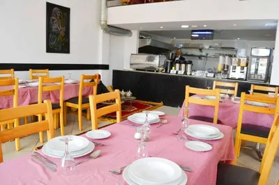 a dining room with a table with pink table cloth at Rose Valley Hotel in Ouarzazate