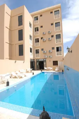 a large swimming pool in front of a building at Rose Valley Hotel in Ouarzazate