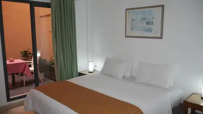 a hotel room with a large bed and a table at Rose Valley Hotel in Ouarzazate