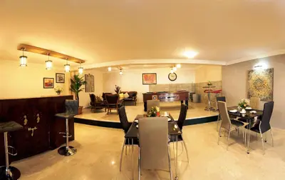 a living room with tables and chairs and a living room at Aparthotel Les Oliviers Suites & Spa in Fès