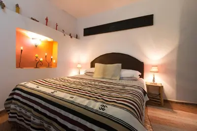 a bedroom with a large bed with a striped blanket at Riad El Ma in Meknès