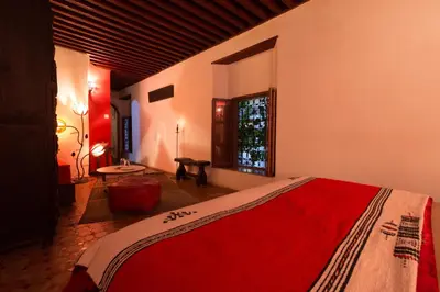 a bedroom with a bed with a red blanket on it at Riad El Ma in Meknès