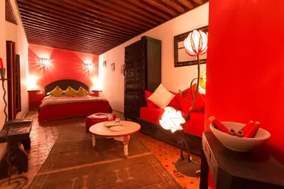 a red bedroom with a bed and a red couch at Riad El Ma in Meknès