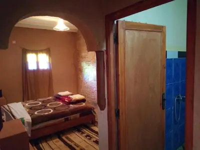 a bedroom with a bed and an open door at Dar Zara in Ouarzazate