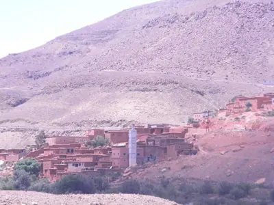 a village on a hill with a mountain in the background at Dar Zara in Ouarzazate
