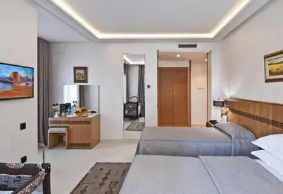a hotel room with two beds and a kitchen at Hôtel l'escale in Fès