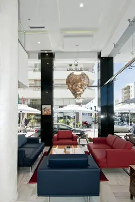 a lobby with red and blue couches and a giant heartendant at Hôtel l'escale in Fès