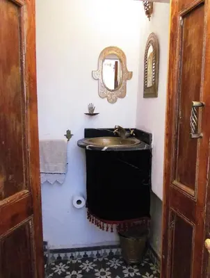 a bathroom with a sink and a mirror at Riad Dar Arsama in Fès