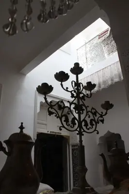 a vase with flowers on a table in a room at Riad Dar Arsama in Fès