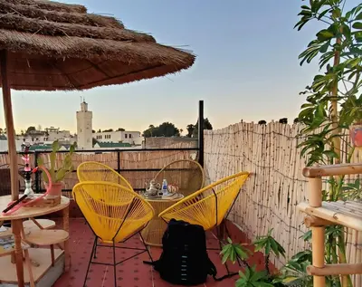 a patio with yellow chairs and a table and an umbrella at la Kasbah salam in Fès