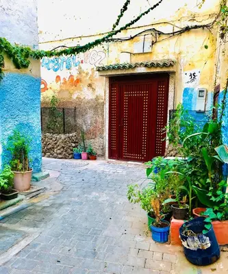 a building with a red door and some potted plants at la Kasbah salam in Fès