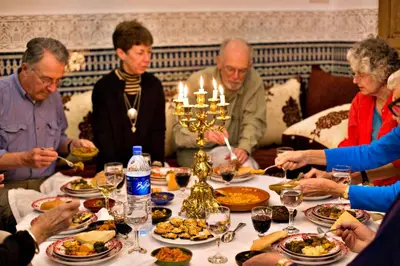 a group of people sitting around a table eating food at Riad Marjana suites & Spa in Fès