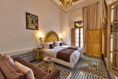 a hotel room with a bed and a couch at Riad Marjana suites & Spa in Fès