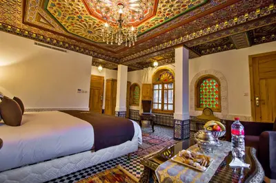 a hotel room with a bed and a chandelier at Riad Marjana suites & Spa in Fès