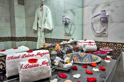 a bathroom with red roses on a table with towels at Riad Marjana suites & Spa in Fès