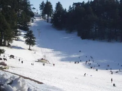 a group of people skiing down a snow covered slope at Le Gite du Barrage in Zaouia Ben Smine