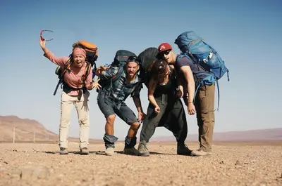 a group of people with backpacks walking in the desert at Bivouac Les Nomades & Foum zguid camel trekking and tours in Foum Zguid