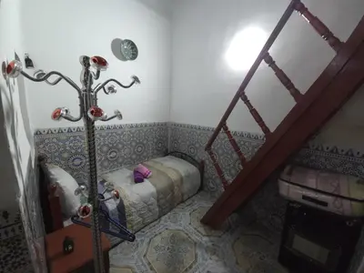 a small room with a bed and a staircase at Dar Enouiina in Fès