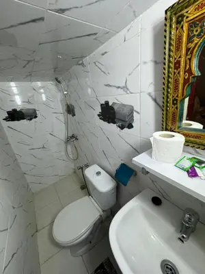 a white bathroom with a toilet and a sink at Dar Enouiina in Fès