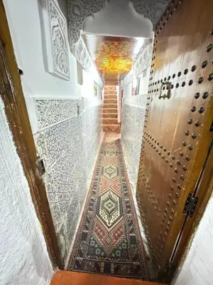 a hallway with a door with a tile floor at Dar Enouiina in Fès