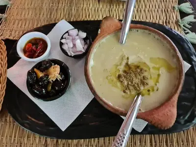 a black plate with a bowl of soup and a spoon at La pommeraie d'Ifrane in Ifrane