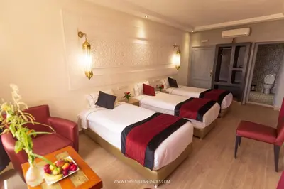 a hotel room with three beds and a table at Ksar Sultan Dades - Dades Valley Retreat in Boumalne