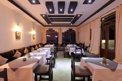 a row of tables in a restaurant with white tables and chairs at Ksar Sultan Dades - Dades Valley Retreat in Boumalne