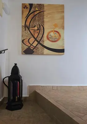 a painting hanging on a wall next to a staircase at Dar Le 44 in Fès