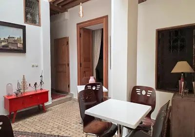 a dining room with a white table and chairs at Dar Le 44 in Fès