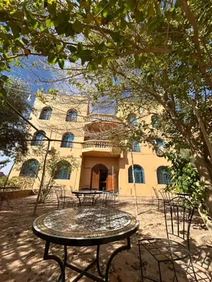 a building with a table and chairs in front of it at Maison D'hotes Sahara in Aoufous