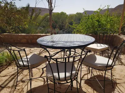 a table and four chairs and a table and chairsktop at Maison D'hotes Sahara in Aoufous