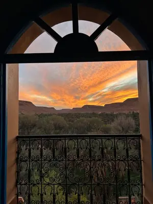 a view of a sunset through a window at Maison D'hotes Sahara in Aoufous