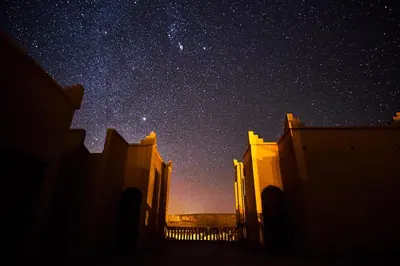 a night view of a star filled sky with buildings at Maison D'hotes Sahara in Aoufous