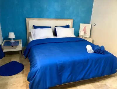 a blue bedroom with a large bed with blue sheets at Teacook Marrakech in Ouled el guerne