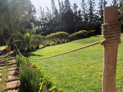 a rope fence with a garden in the background at Teacook Marrakech in Ouled el guerne