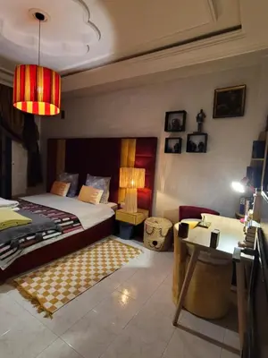 a bedroom with a bed and a table and a desk at Appartement de haut standing in Fès