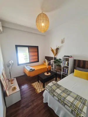a bedroom with a bed and a couch and a window at Appartement de haut standing in Fès
