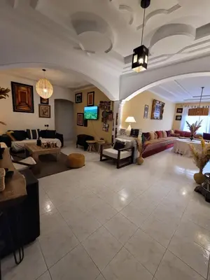 a large living room with couches and tables at Appartement de haut standing in Fès