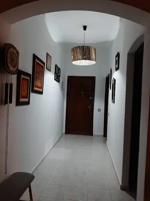 a hallway with a room with a door and pictures on the walls at Appartement de haut standing in Fès